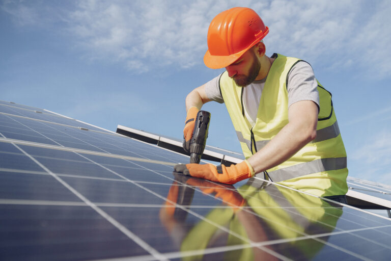 Monteur installiert Photovoltaikanlage (PV-Anlage) auf dem Dach.